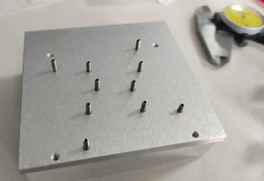 Aluminum heat sink mounting face with threaded mounting posts and fixing holes